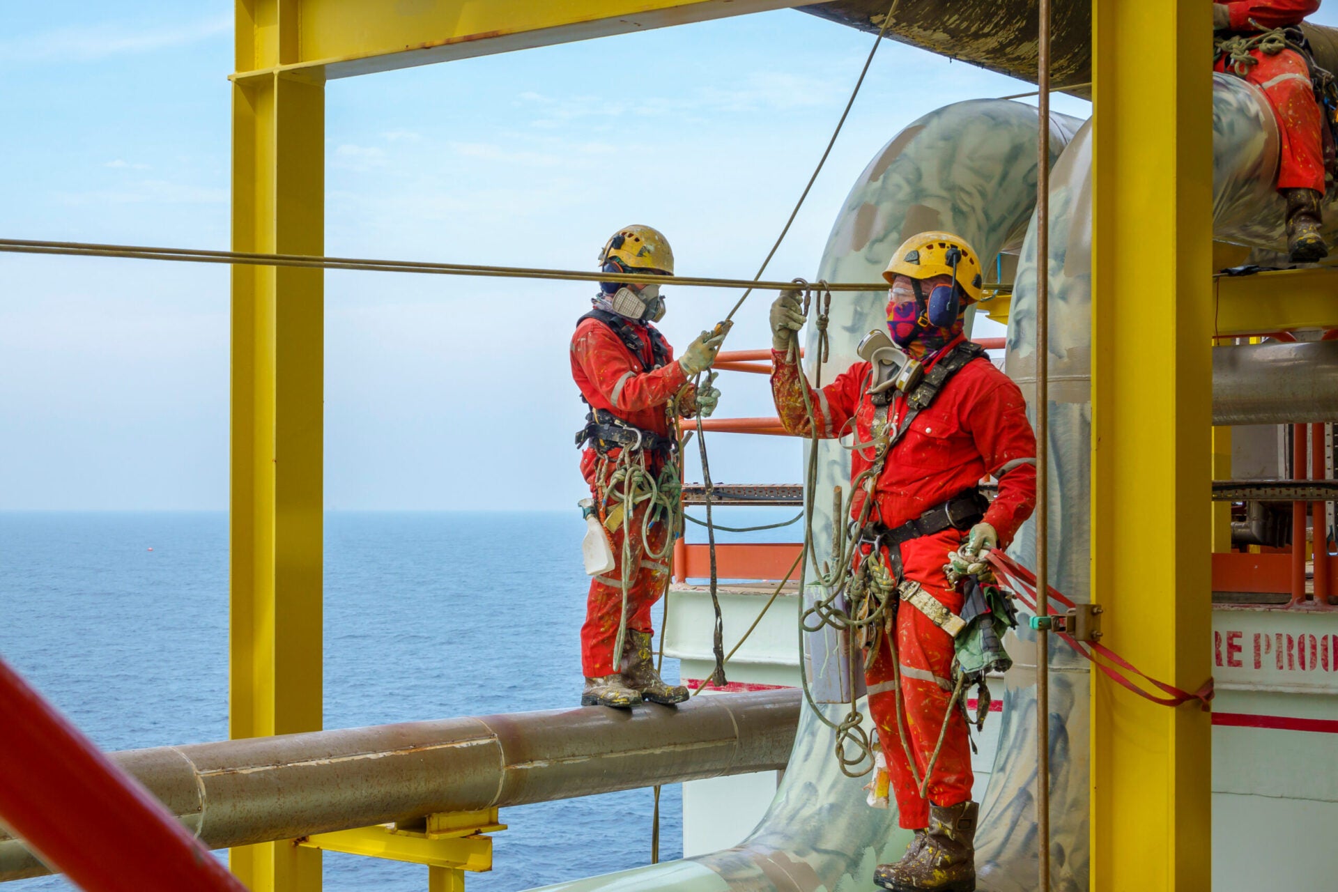 Workers wearing PPE equipment offshore in oil and gas industry