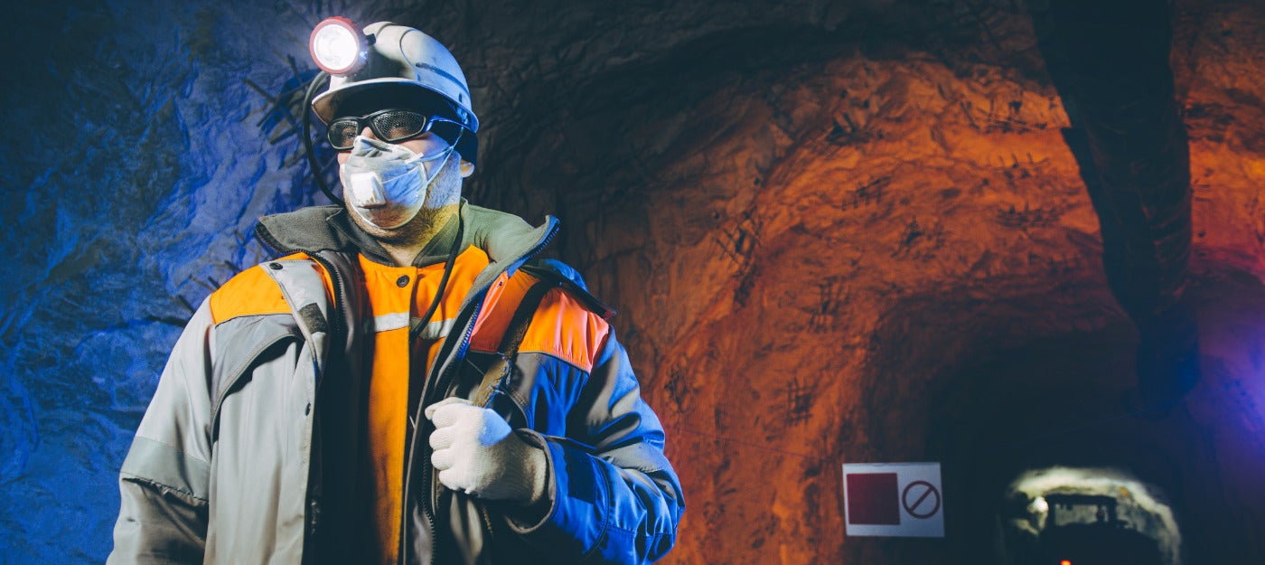 A Miner Wearing A Mining Helmet With Headlamp Underground