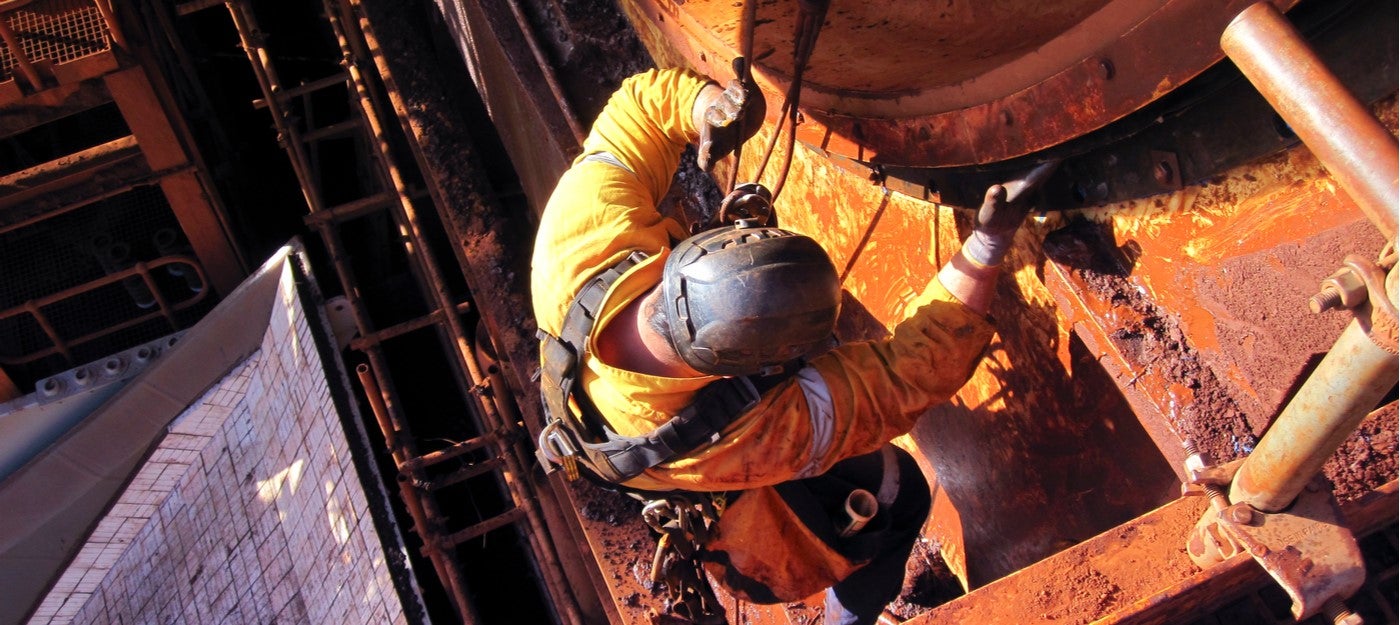 Preventing falls, industrial worker working at height with harness attached